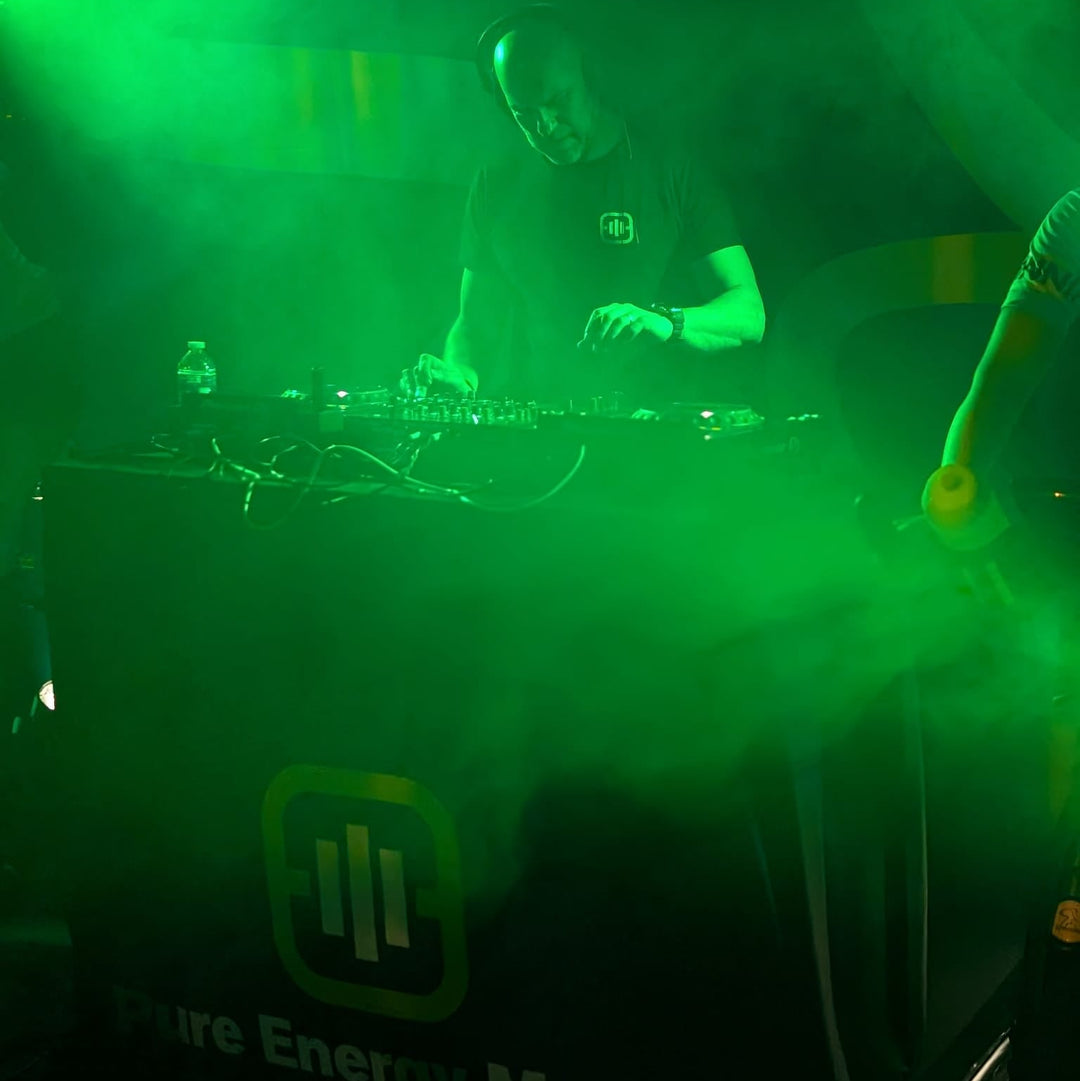 Andy Pickles at the PROS 2026 DJ booth with green lighting and 'Pure Energy Music' branding.